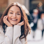 Brunette woman with clear braces smiles happily in Weatherford, TX