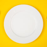Aerial view of an empty place setting on a yellow background